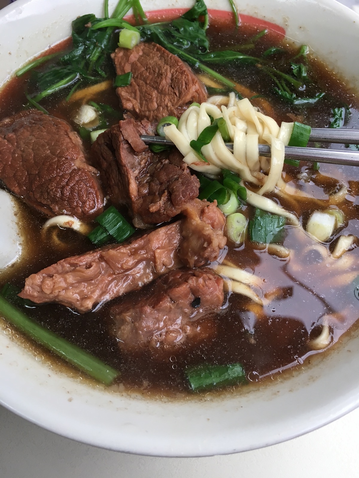 A bowl of Taiwanese beef noodle soup (牛肉麵) with braised beef, noodles, and bok choy