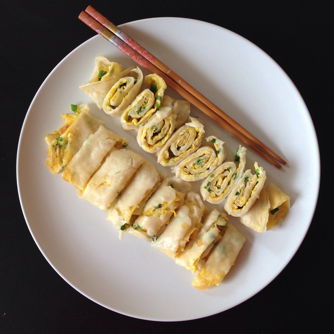 A rolled Taiwanese egg crepe (蛋餅), sliced, fresh off the griddle