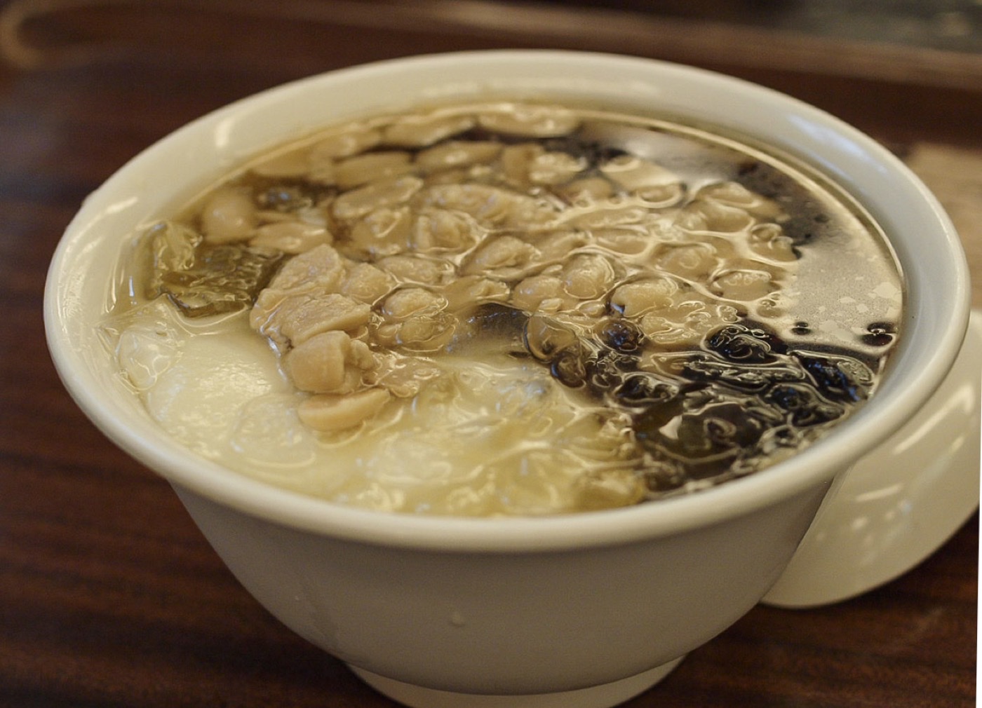 A bowl of tofu pudding (豆花) with peanuts and toppings at a Taipei dessert shop